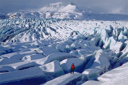 Ihminen seisoo islantilaisella jäätiköllä